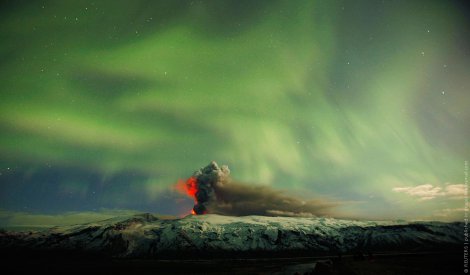 Исландия. Северное сияние на фоне извержения вулкана